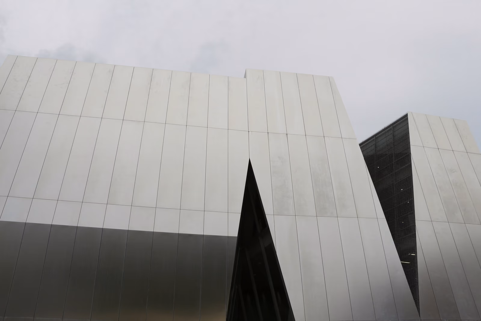 Les façades anguleuses en aluminium du musée Sumida Hokusai, signé Kazuyo Sejima, sous un ciel gris