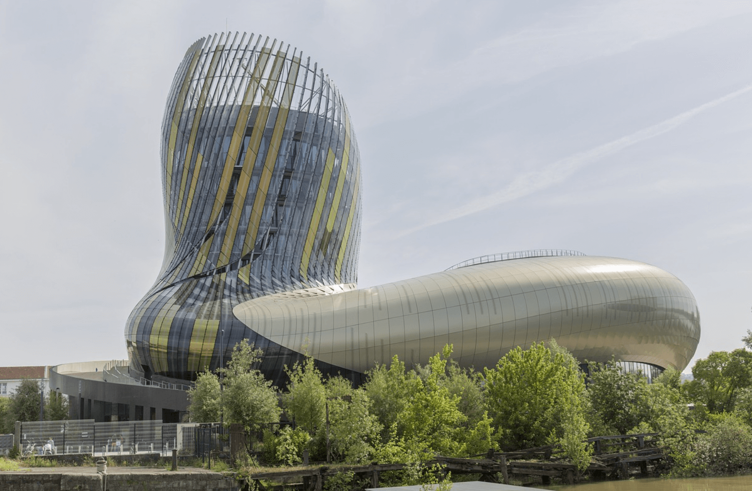 Photo de la Cité du Vin à Bordeaux, un bâtiment emblématique à l'architecture moderne et audacieuse, dédié à la culture du vin, situé au bord de la Garonne dans un cadre verdoyant.