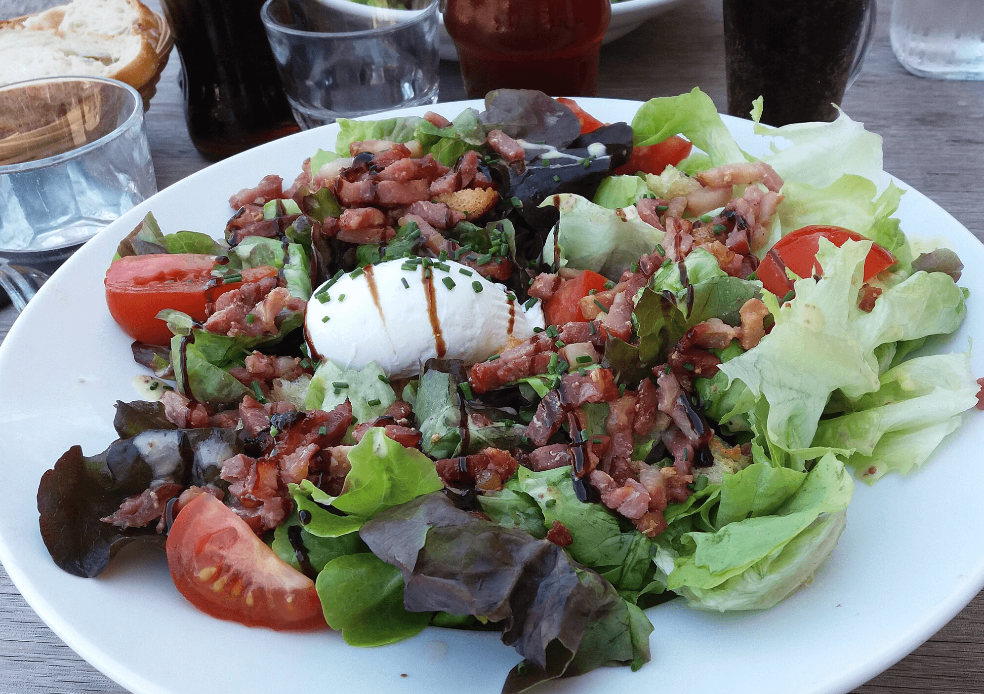 Une salade verte composée de lardons et croûtons